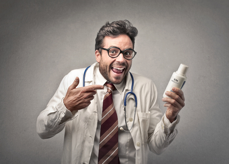 doctor smiling showing a medicine の写真素材