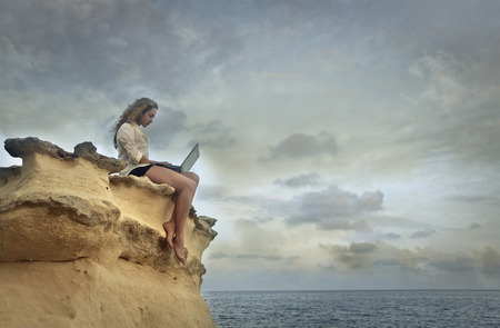 Using a pc at the seasideの写真素材