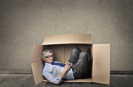 Businessman lying in a box