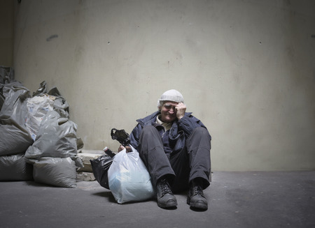Homeless man sitting on the groundの写真素材
