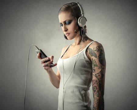 Tattooed girl listening to musicの写真素材