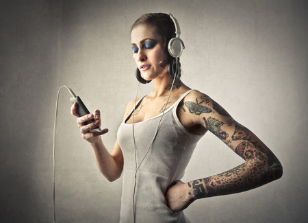 Tattooed girl listening to musicの写真素材