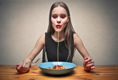 Girl eating pastaの写真素材