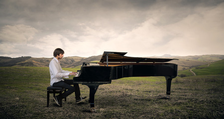 Man playing the piano in a fieldの写真素材