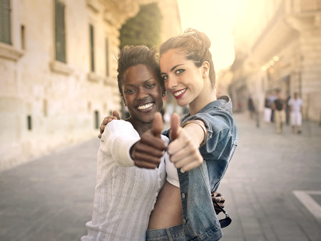 Two young girls with thumbs upの写真素材
