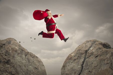 Santa Claus jumping from a rock to anotherの写真素材
