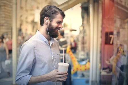 Smiling bearded man holding a milkshakeの写真素材