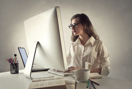 Young lady using two pcsの写真素材