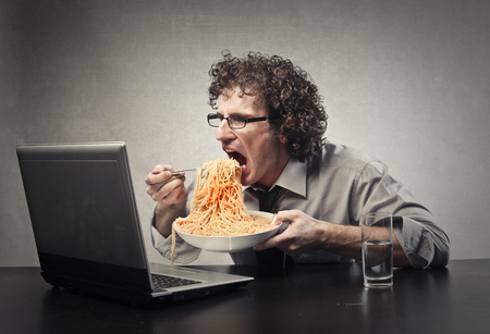 Hungry man watching a movie on his laptop Hungry man watching a movie on his laptop