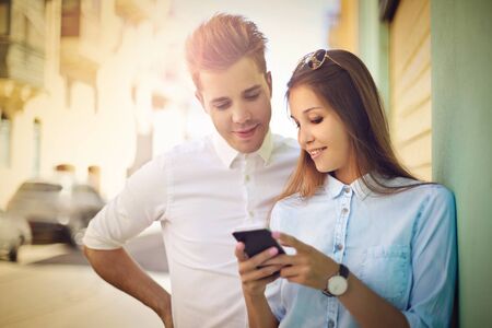 Man and his girlfriend looking at the screen on a phone