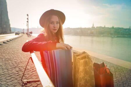 Young lady sitting on a bench by the riverの写真素材