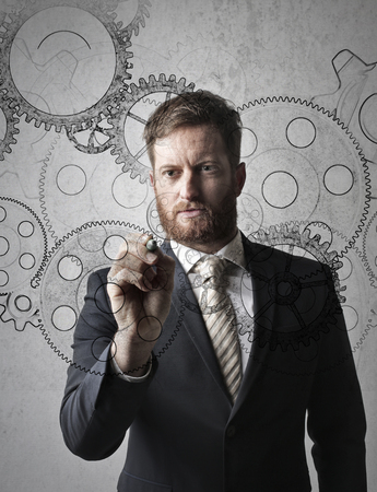 Businessman drawing gearsの写真素材