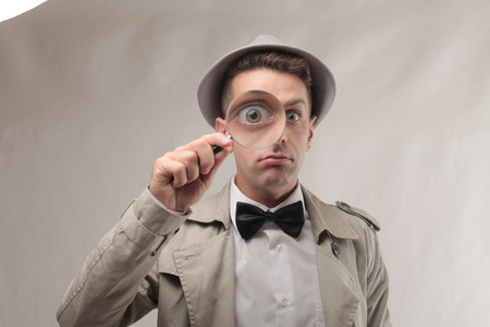 Retro dressed man with magnifying glassの写真素材