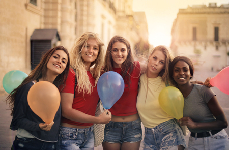 Happy girls holding colorful balloonsの写真素材