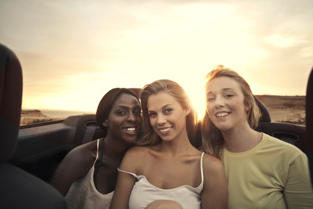 Smiling girls sitting in a carの写真素材
