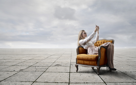 Blonde woman sitting in a luxury armchairの写真素材