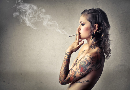 Tattooed woman smokingの写真素材