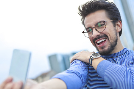 Excited man doing a selfieの写真素材