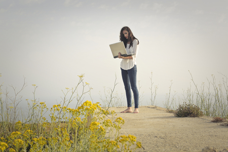 Woman using a laptop in the open airの写真素材