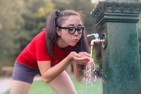 Thirsty teenager drinking at the park