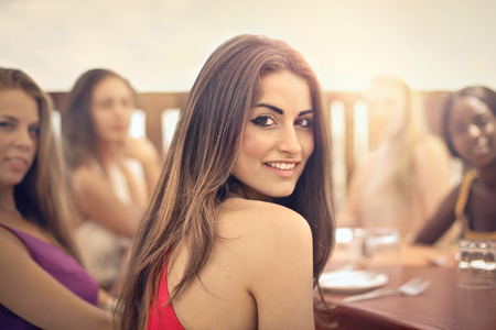 Beautiful women sitting at a tableの写真素材