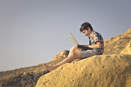 Young boy addicted to technologyの写真素材