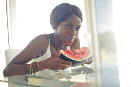 black woman is eating a watermelonの写真素材