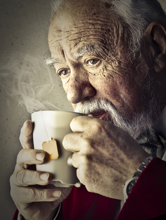 Old man is drinking a hot teaの写真素材