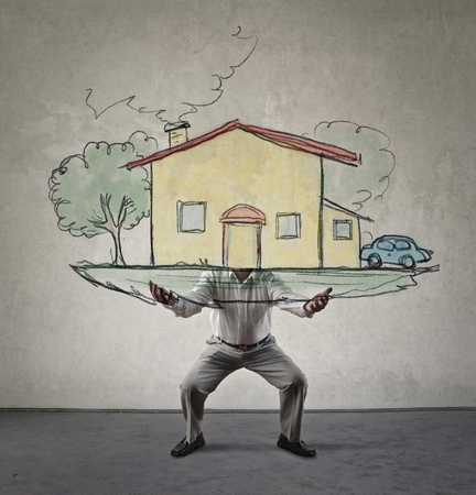 Man is holding a house in his handsの写真素材