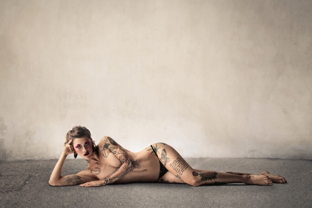 Pretty, nude tattooed womanの写真素材