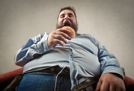 Fat Man is eating the burgerの写真素材