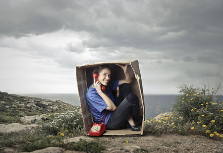 Woman even if having a phonecall in the boxの写真素材