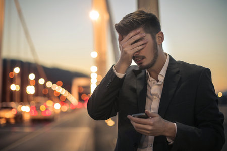 Businessman has some problem with his phoneの写真素材