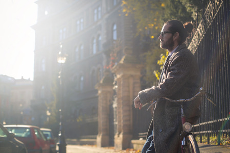 Businessman is waiting while sitting on his bikeの写真素材