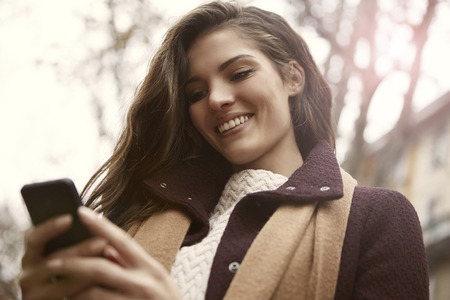 Happy woman is writing a messageの写真素材