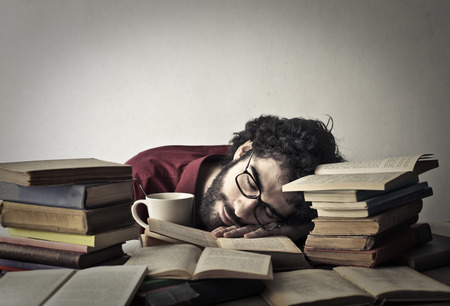 The student is sleeping with his booksの写真素材