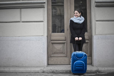 The girl is waiting with a suitcaseの写真素材