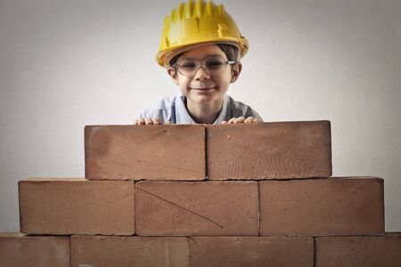 Little boy is building a wall