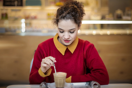 Pretty girl is drinking a cappuccino