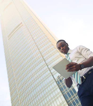 Businessman next to a skyscraperの写真素材