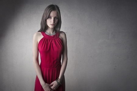 Pretty, serious woman in red dressの写真素材