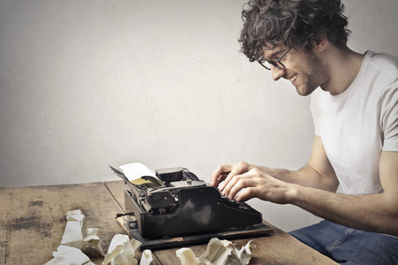 Guy is using an old typewriterの写真素材
