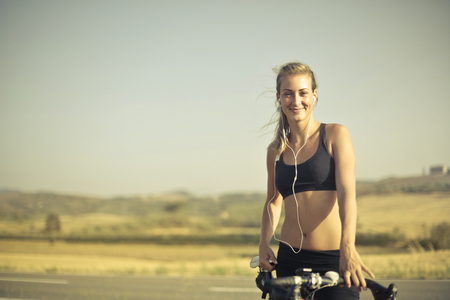 Girl with a bike in the countrysideの写真素材
