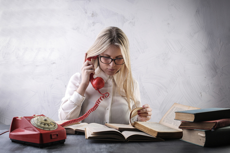 Girl with vintage books and telephoneの写真素材
