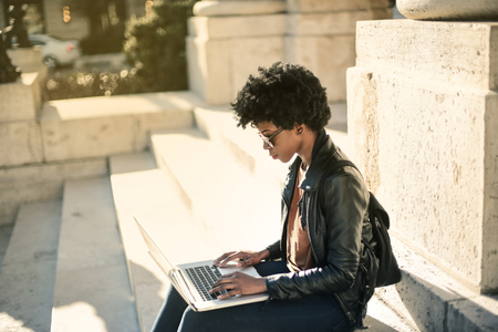 Young woman using a laptop outdoorの写真素材