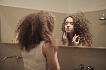 Girl looking at the mirrorの写真素材