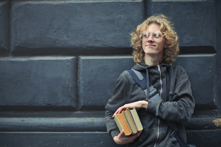 Guy holding some books outdoor