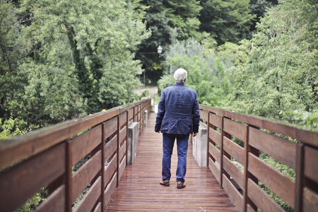 Aged man walking in a natural contextの写真素材
