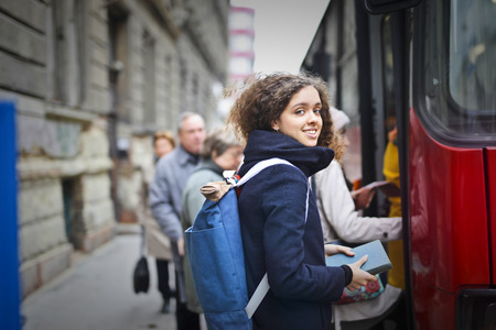 Girl with a backpack going on a busの写真素材
