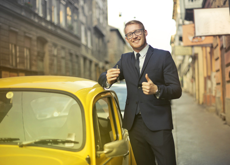 Businessman near a yellow carの写真素材